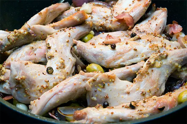 Rabbit legs stewed in wine, with bacon and garlic