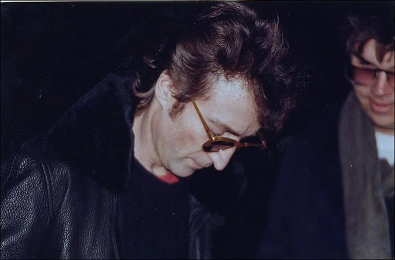 Lennon gives autograph to his murderer Mark Chapman (right)