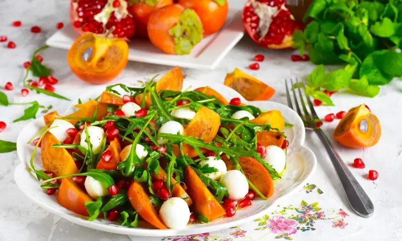 A feast for the eyes: a recipe for a salad with persimmons, mandarins, and cheese.