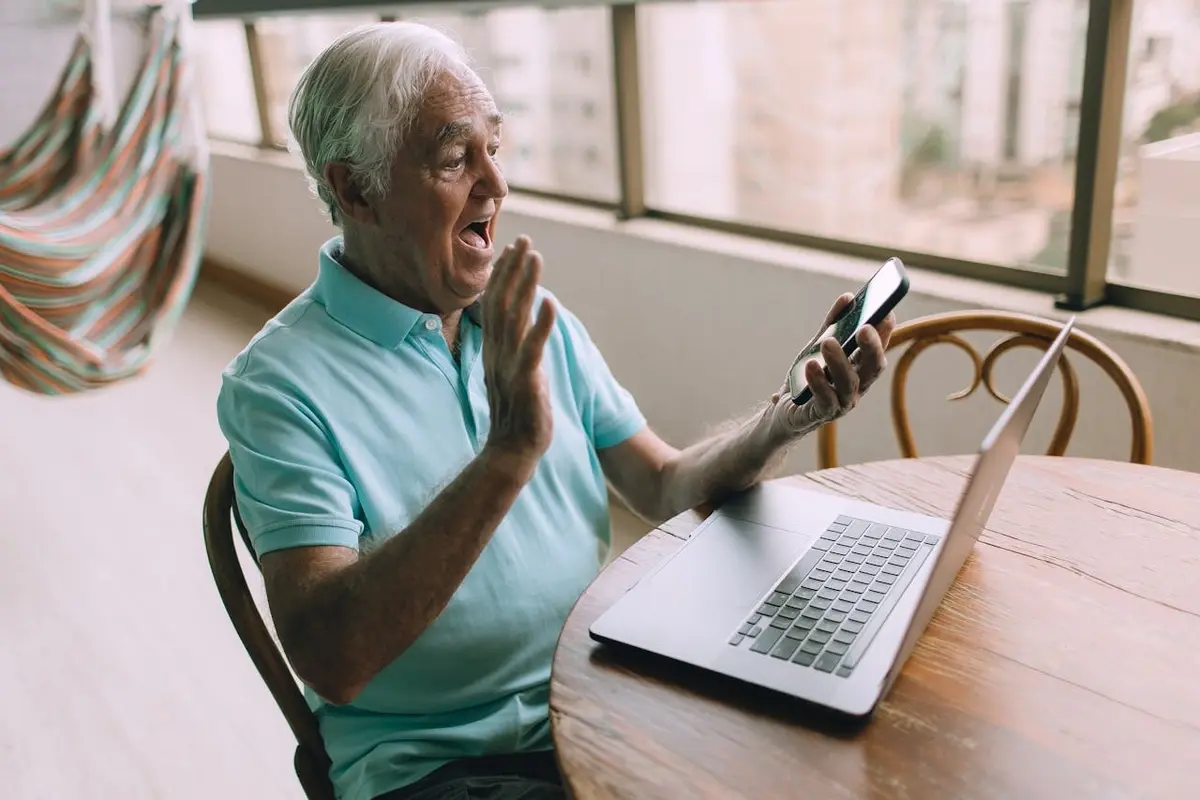man with a phone and laptop