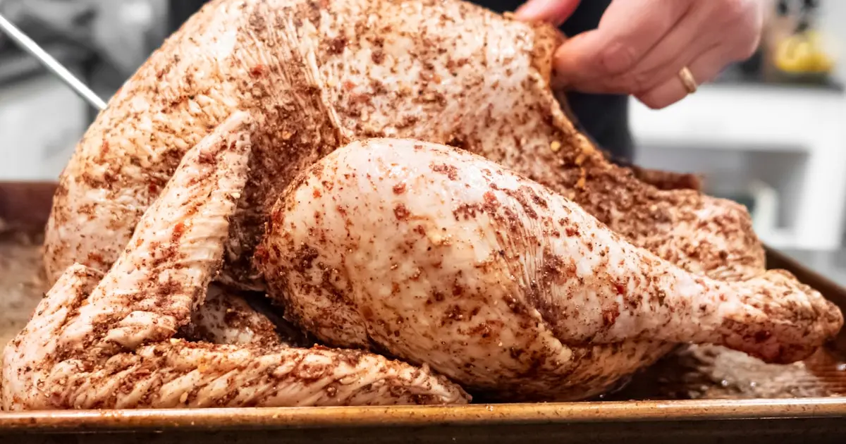 A person slicing a turkey on a tray