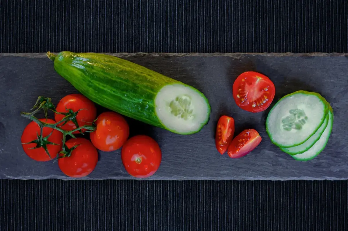 Cucumber and tomatoes sliced on a board