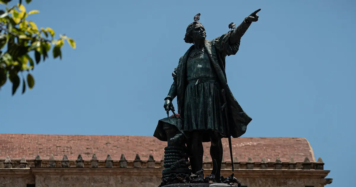 black statue of man holding yellow umbrella
