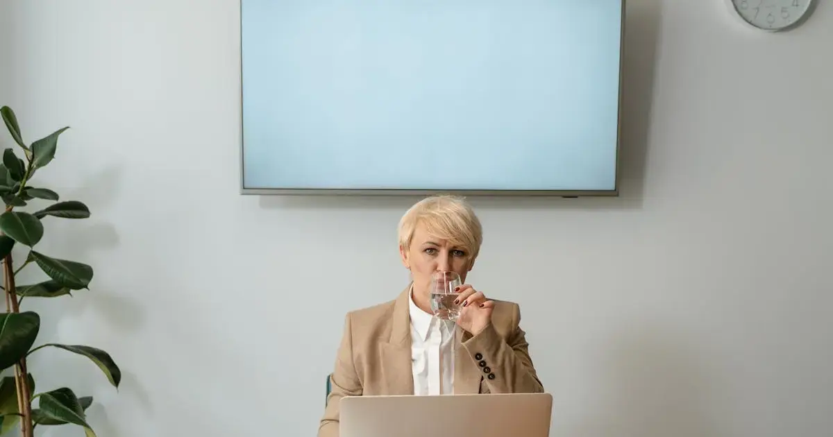 woman with a glass of water at her desk