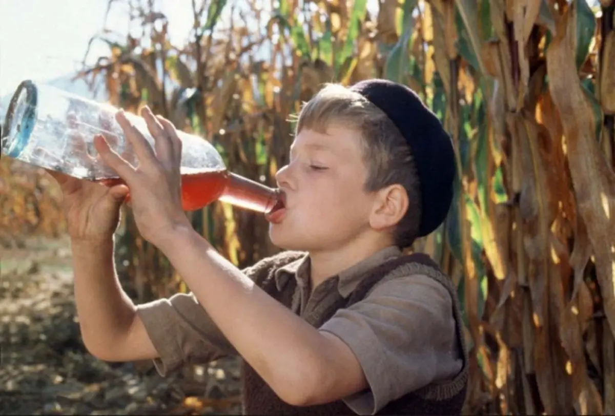 A Child Drinking Wine from a Bottle