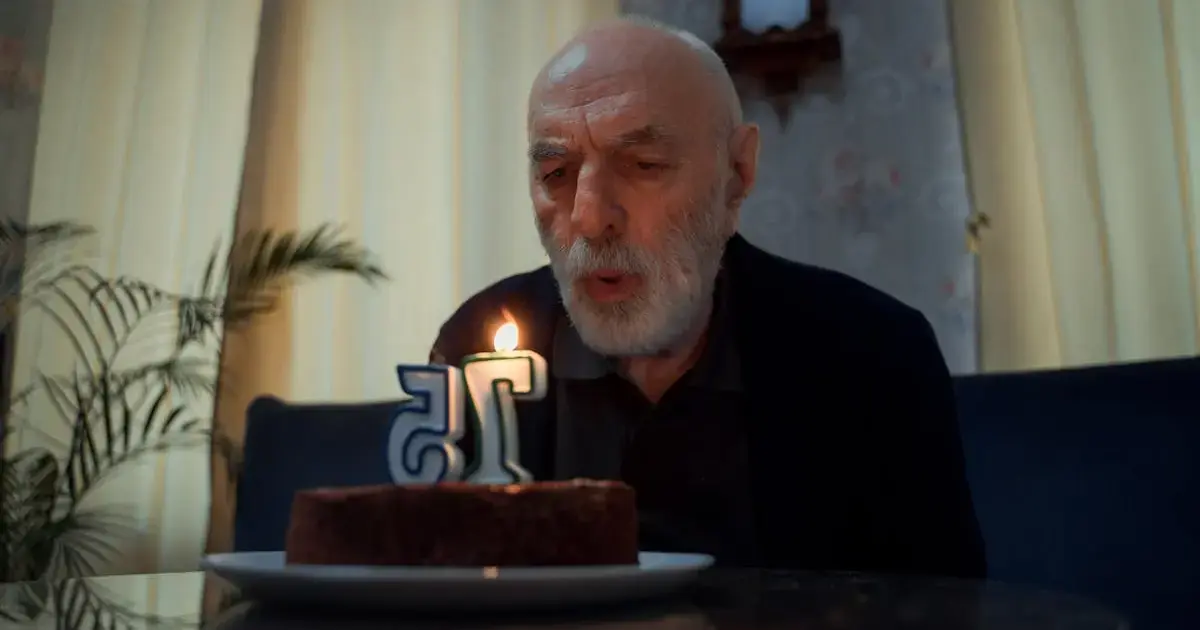 Man blowing out candles on a cake