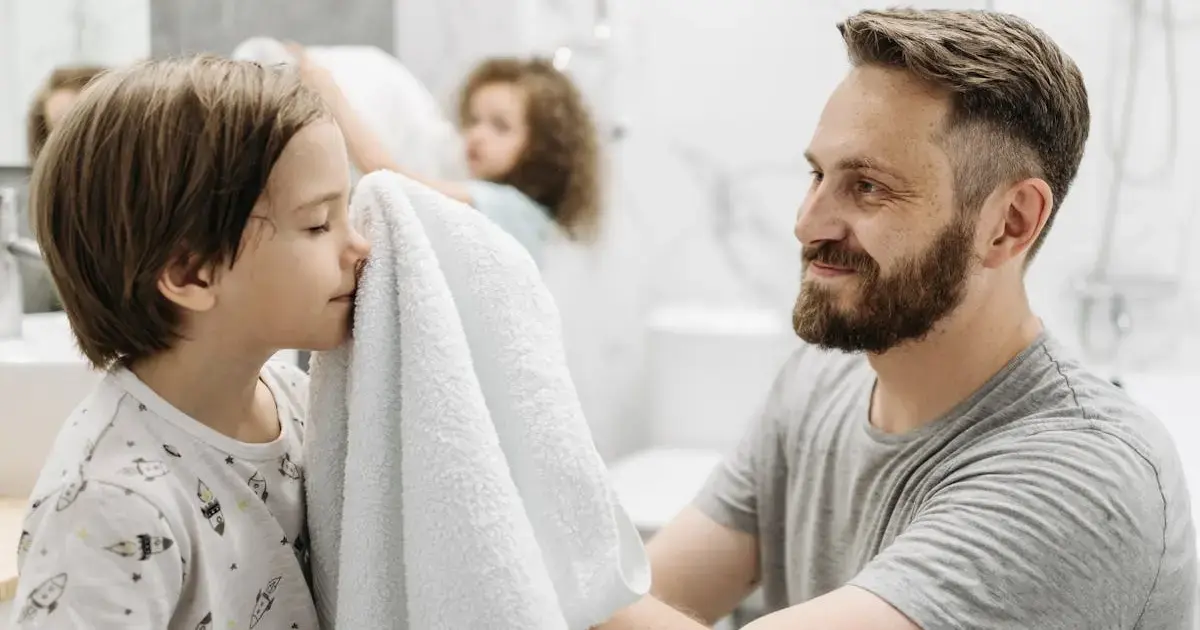 father drying child with a towel