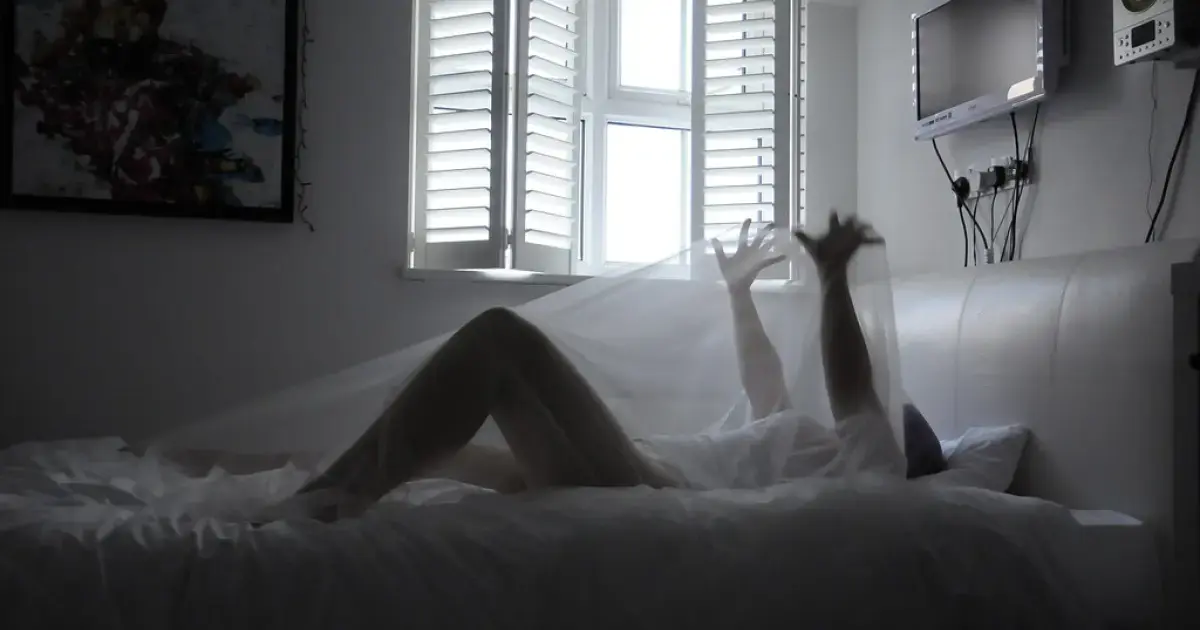 man lying in bed unable to sleep