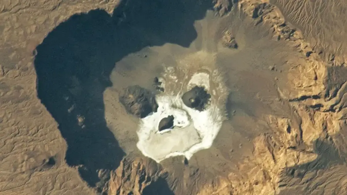 A grumpy 'skull' peeks out from a giant caldera in the Sahara