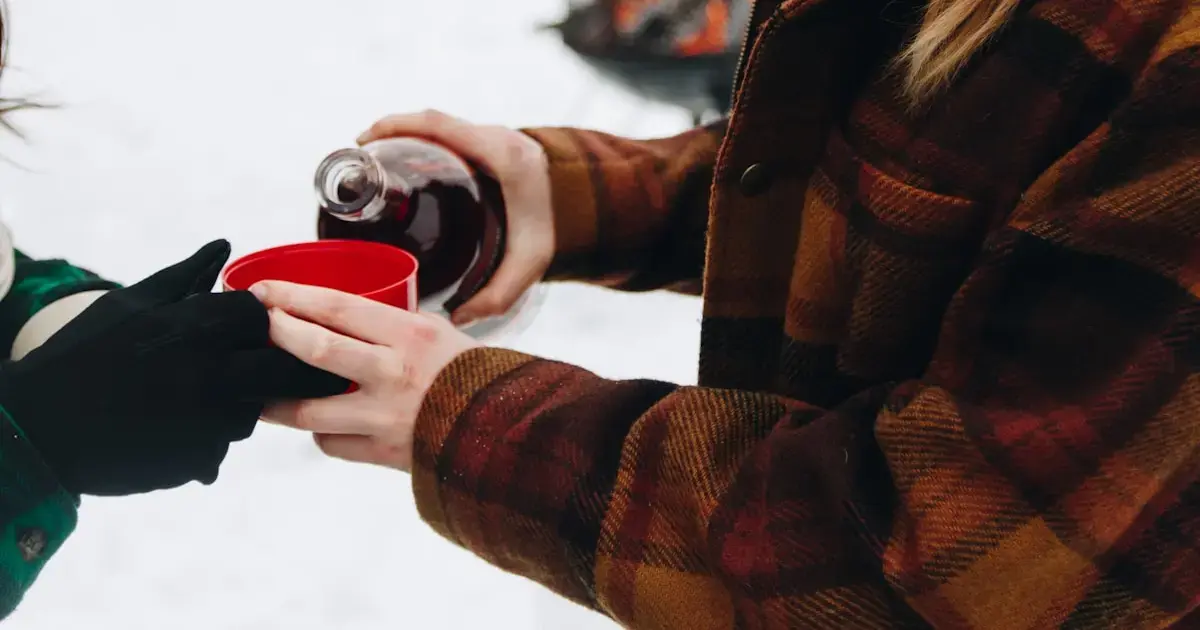 woman pouring wine into a cup outside