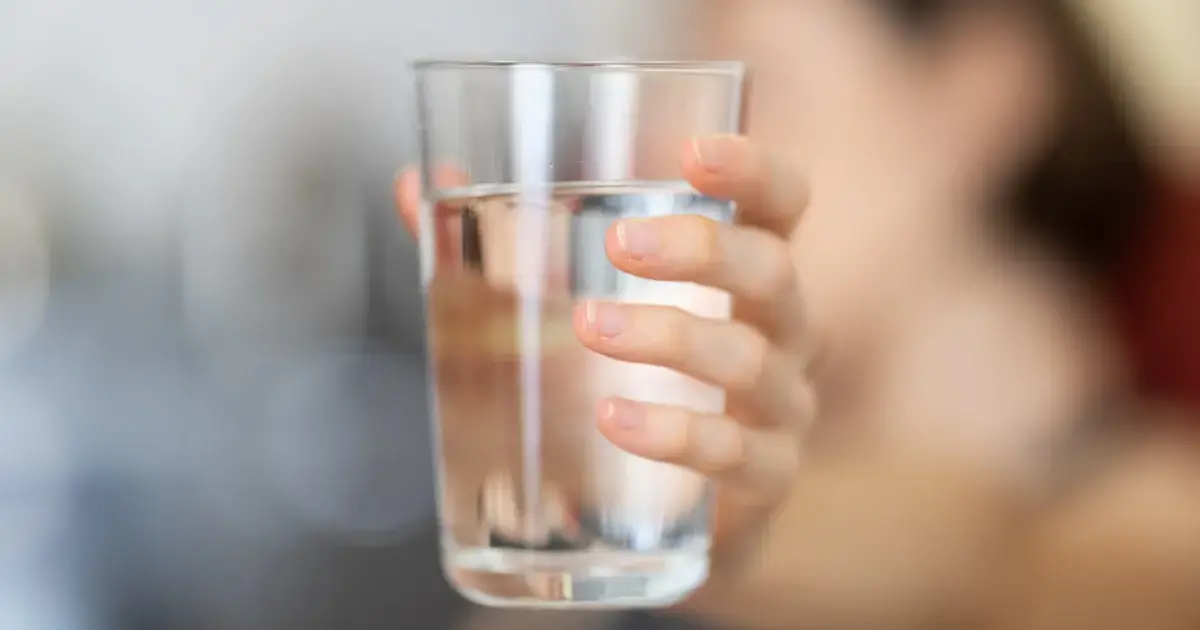 woman holding a glass of water
