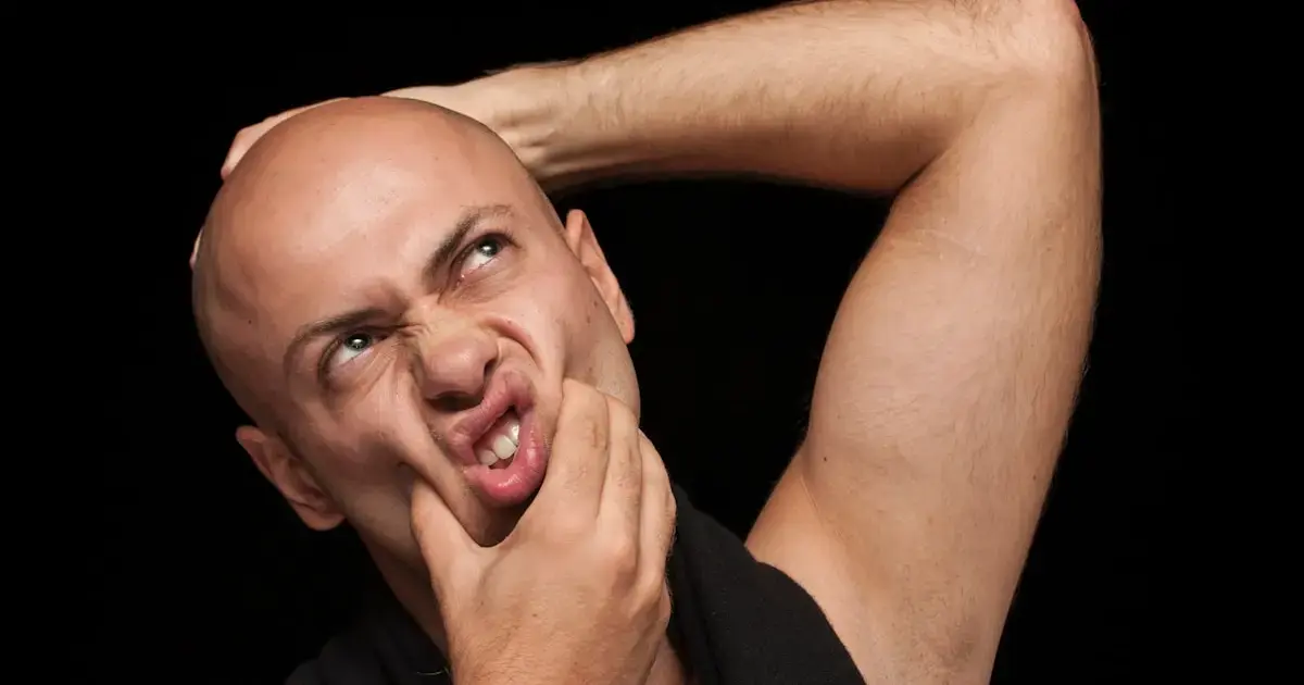 bald man holding his head