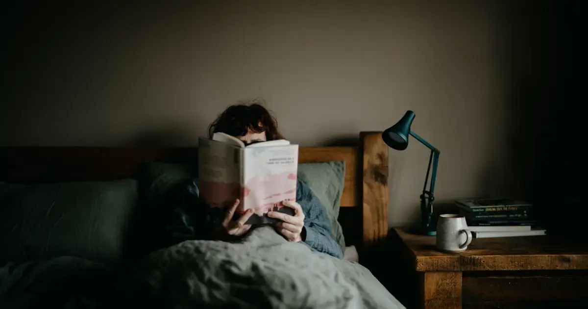 woman reading a book in bed