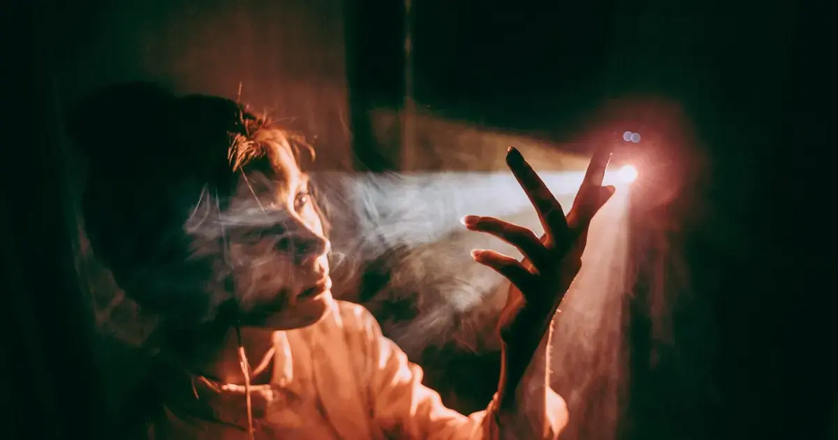 woman in a dark room with a beam of light