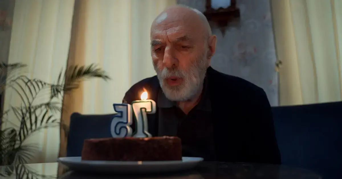 A man blowing out candles on a cake