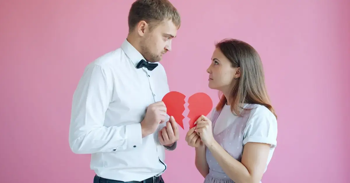 man and woman tearing a paper heart