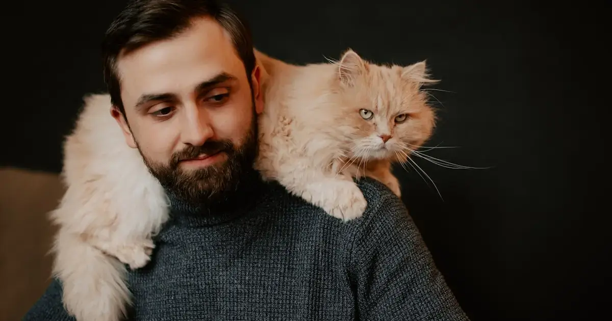 man with a cat on his shoulders