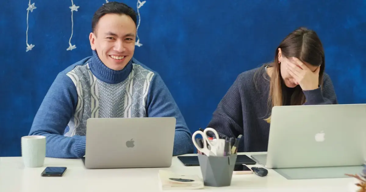 man laughing, woman covering her face with her hand