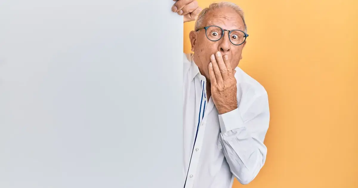 A frightened man peeks around a wall