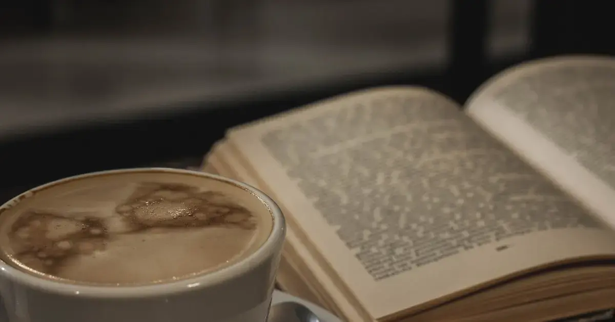 a cup of coffee and a book on a table