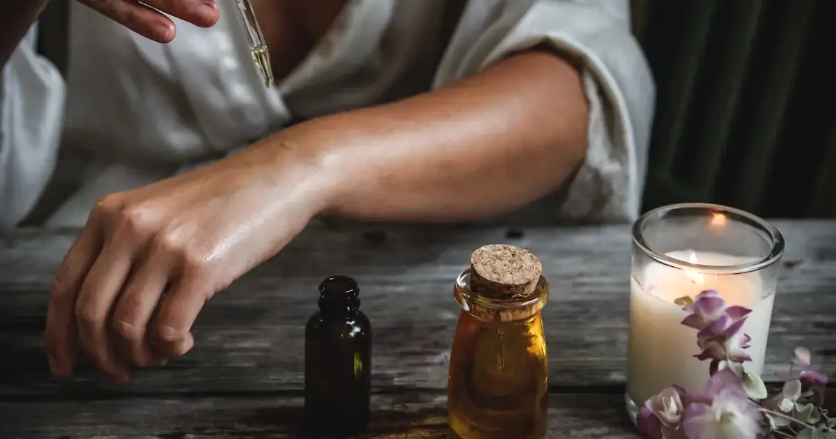 woman's hands and almond oil in a bottle on a table