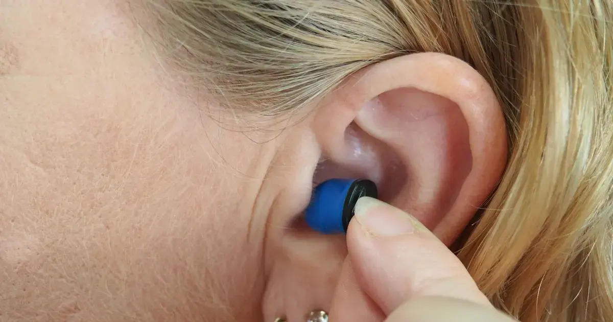 woman inserting earplugs