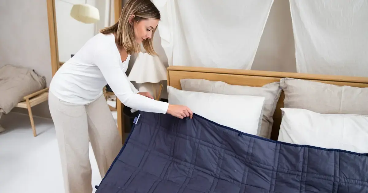 woman making the bed with clean linens