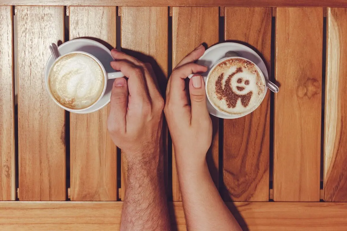 Male and female hands holding cups of coffee