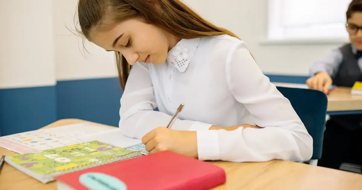 Left-handed child writing in a notebook