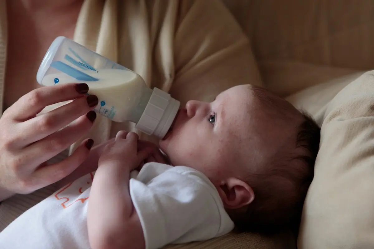 woman feeding a baby with a bottle