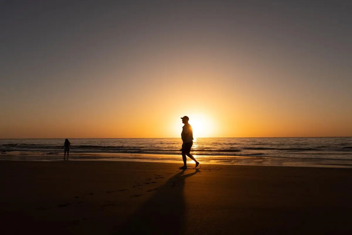 man walking along the beach